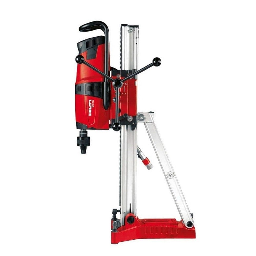 Close-up view of a heavy-duty concrete core drilling machine with a mounted diamond drill bit.