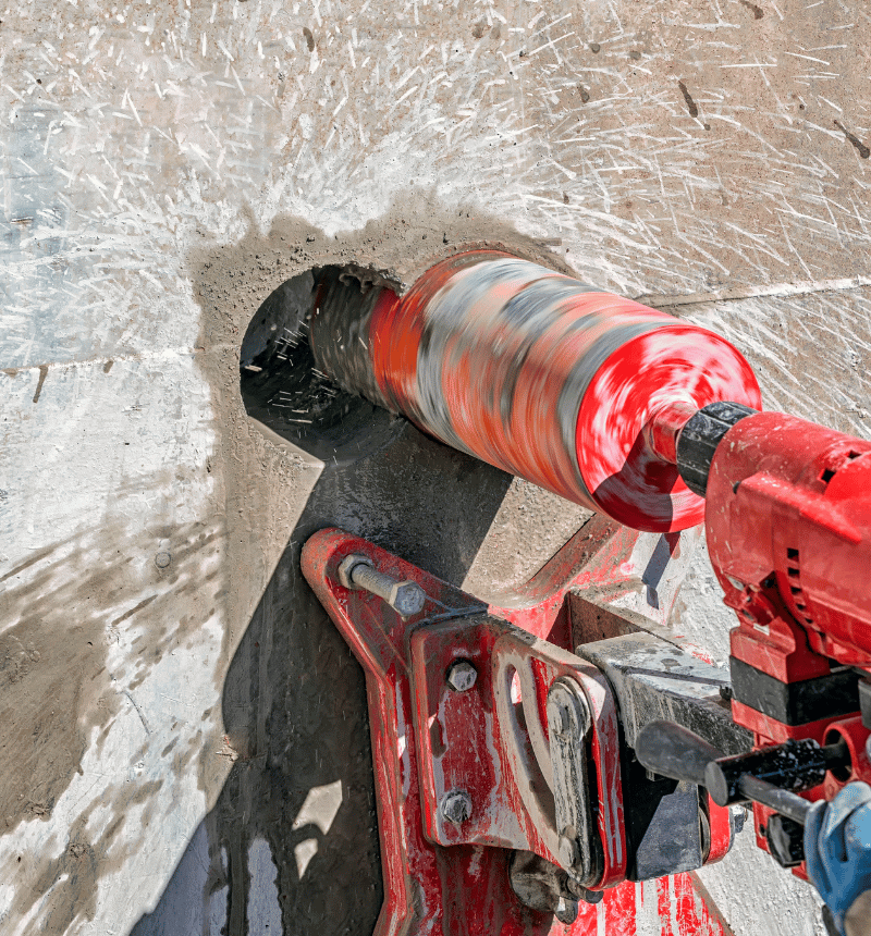 Wet concrete core drilling with water flow used for cooling and dust suppression.